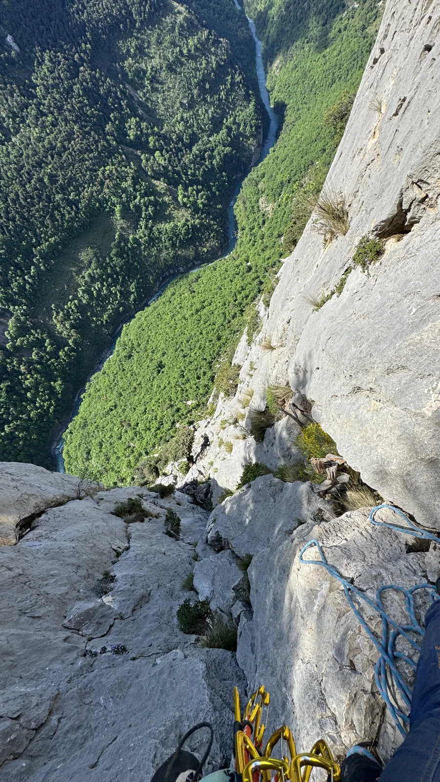 Vue plongeante depuis une paroi vers la gorge, friends colorés visibles au premier plan