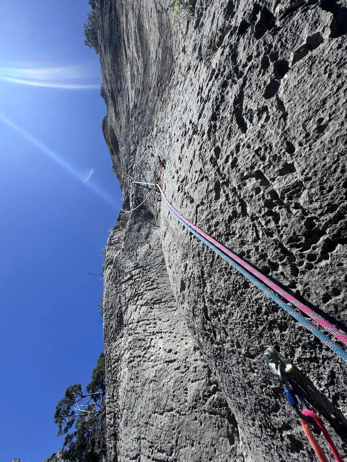 Paroi en contre-plongée avec cordes et soleil