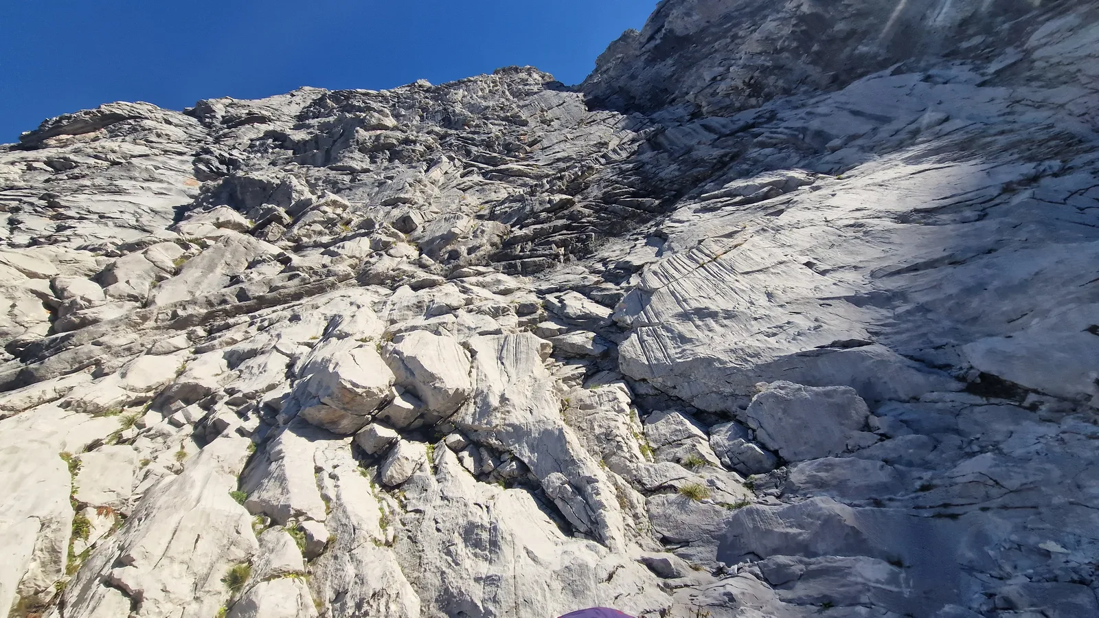 Leader minuscule en haut de grande paroi calcaire massive