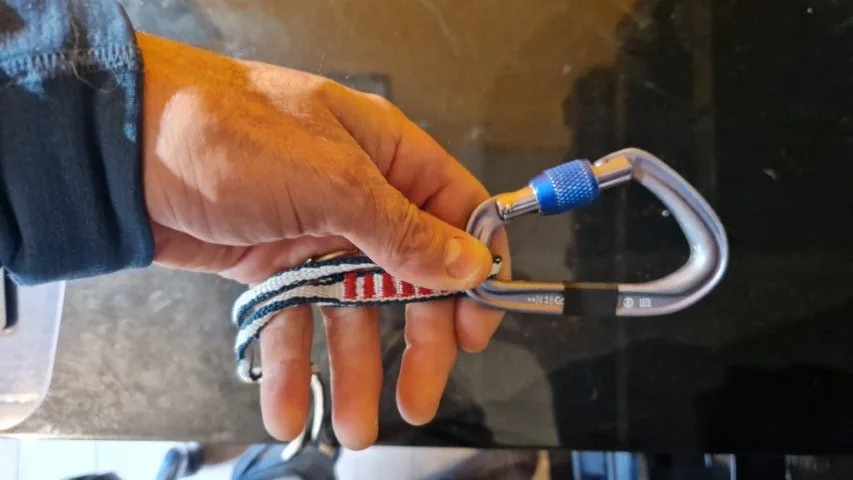 1. Passer un mousqueton au niveau de la couture de la sangle pour remplacer le nœud de la poupée de cordelette