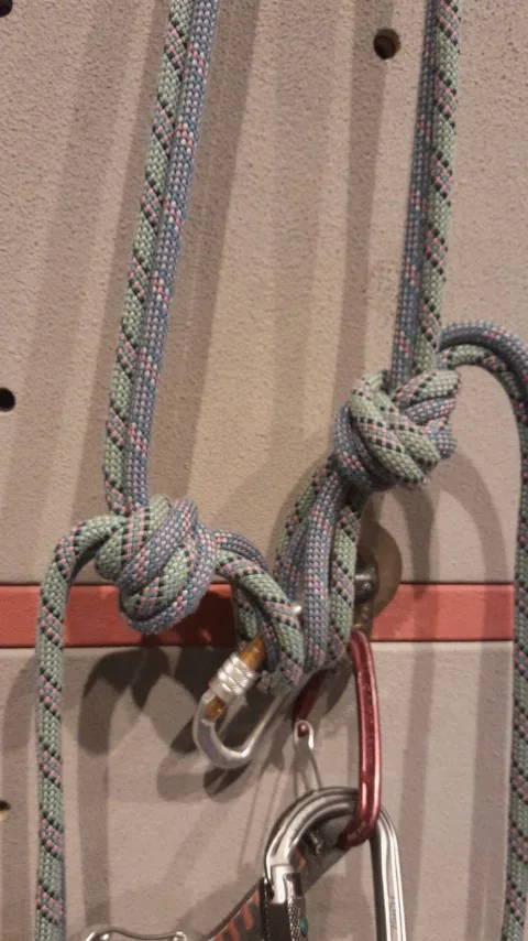 5. Faire une boucle avec un nœud simple sur le retour des cordes pour fermer les deux points. Le plus tendu possible avec le mousqueton vers le bas. Passer la boucle dans le mousqueton à vis et le fermer.