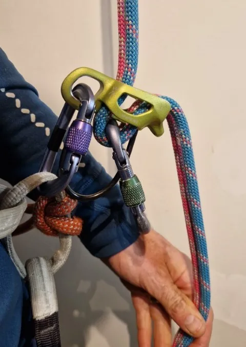 2. Passer la corde avec le brin descendant côté assureur, donc du côté de la main ( à faire donc un demi tour pour la corde pour la positionner dans le bon sens) et mettre mousqueton à vis ( ou dégaine relié pontet)