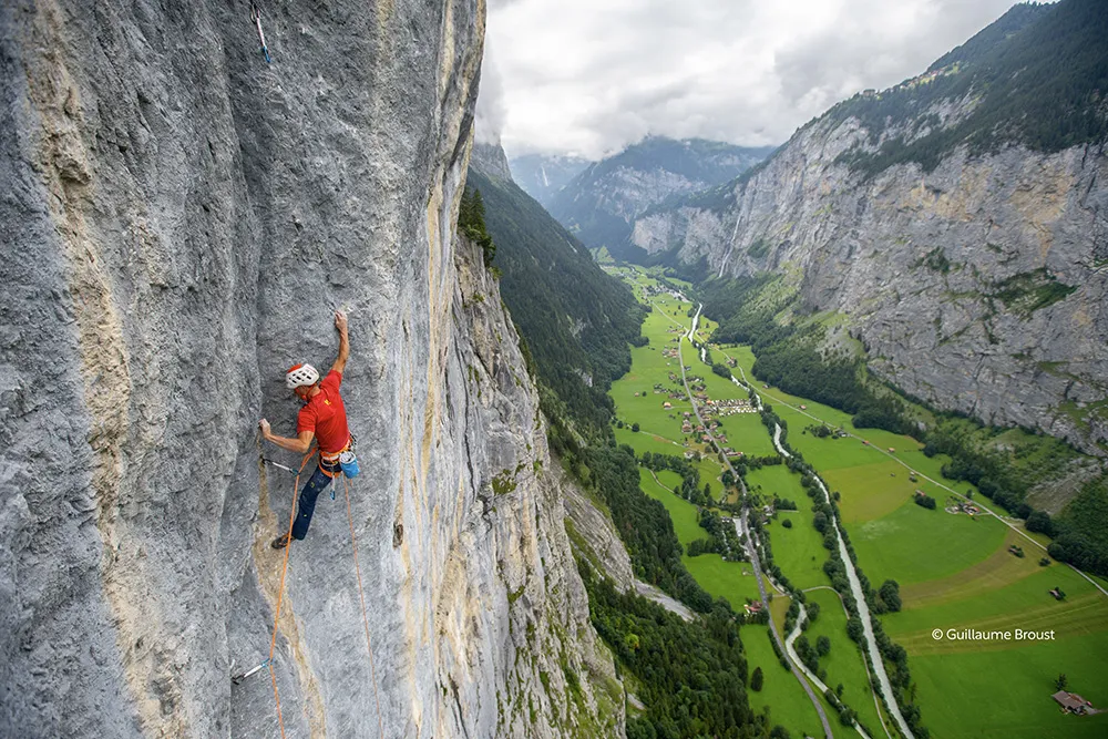 Grimpeur sur une paroi calcaire au-dessus de la vallée de Lauterbrunnen